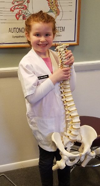 Young aspiring chiropractor with a spine model